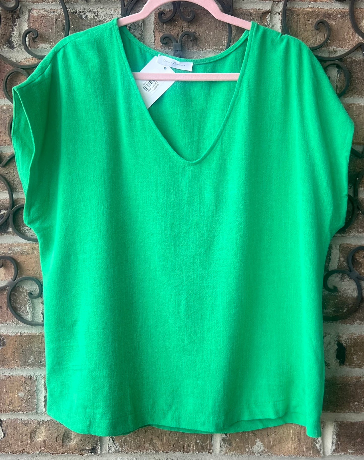 Short sleeve green top. It is linen and rayon. This top would look great with white pants or shorts.
