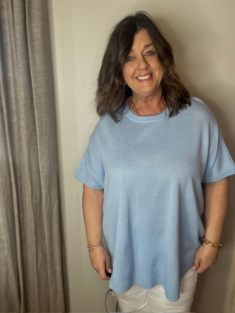 Light blue knit top with u neck. Dolman sleeves, curved hem line, non-sheer and lightweight. This is a great transitional top. Run oversized.